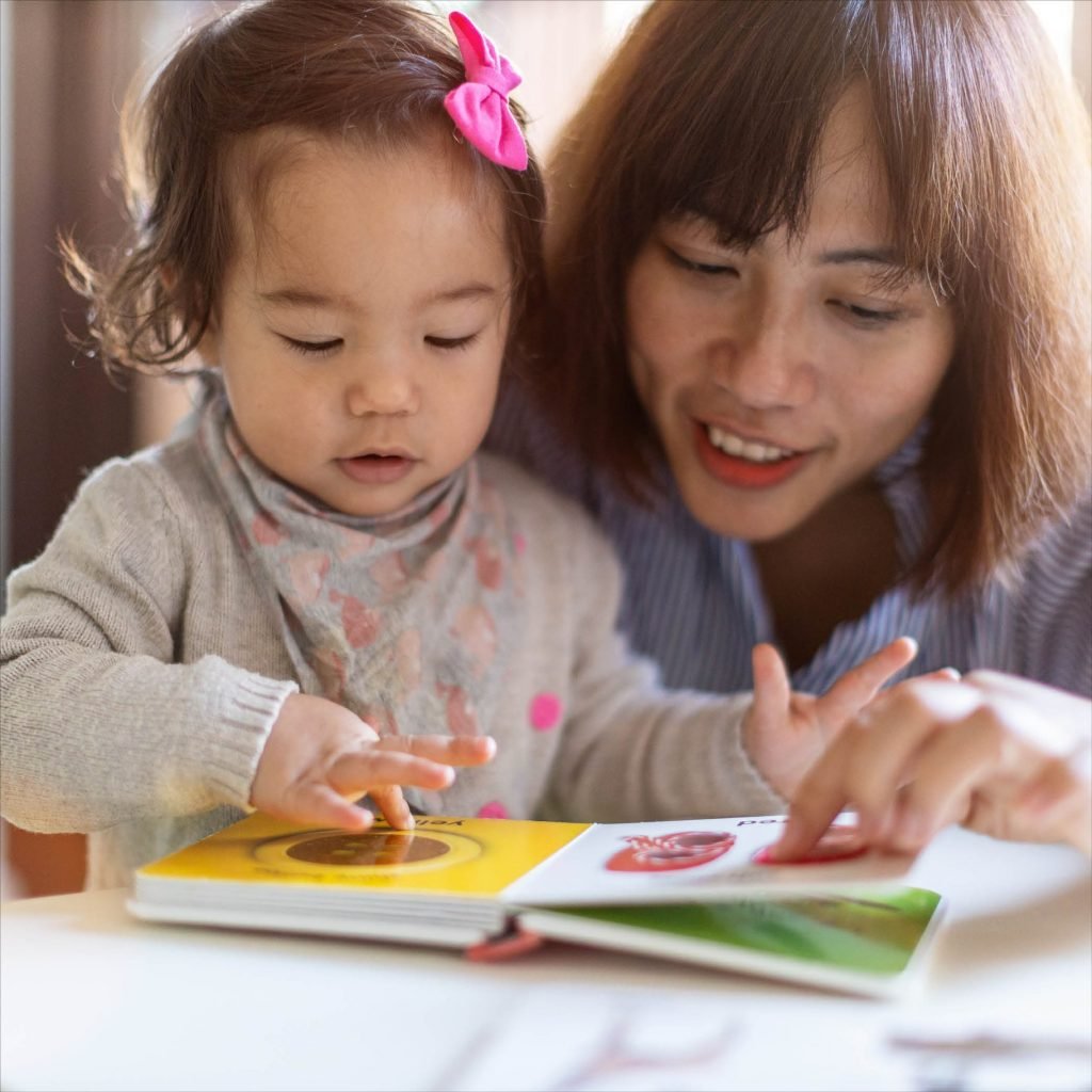A parent and young child reading a story together.