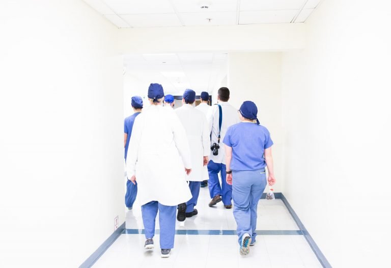 Team of healthcare workers wearing scrubs and caps.