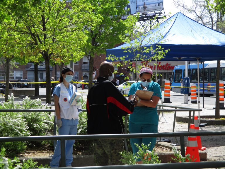 Staff of CIUSSS West Central takes down a resident's contact information outside the mobile COVID-19 testing clinic, set up beside Parc metro station in Montreal's Park Extension borough. Photo: Avleen K Mokha